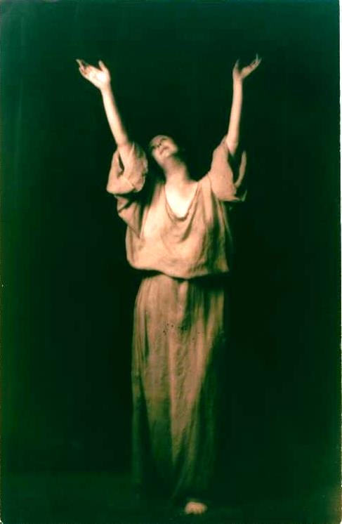Isadora Duncan levant les bras et vêtue d'une tunique antique