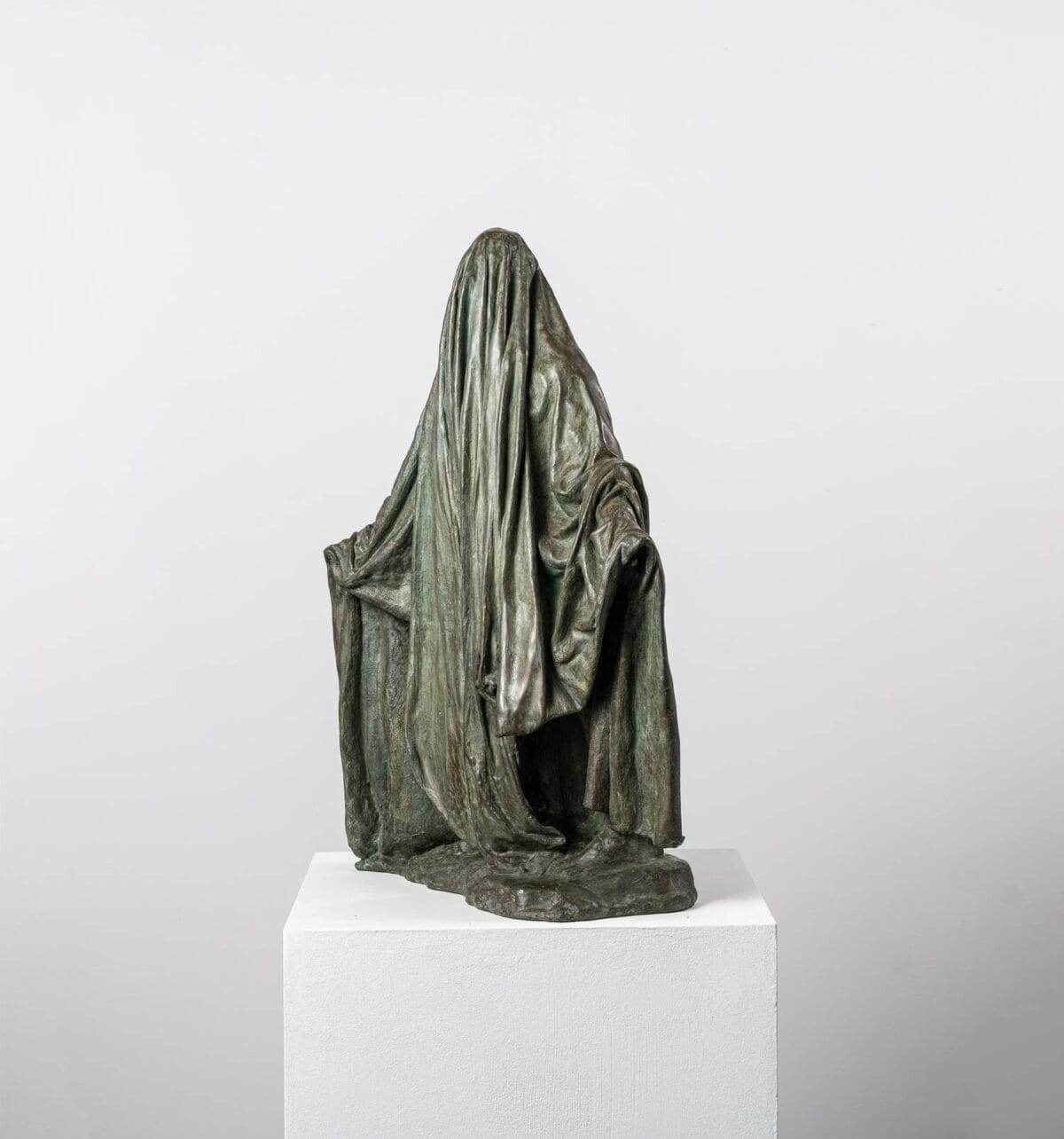 "Ombre voilée II" est une œuvre en bronze de Guy Le Perse, mettant en scène un personnage voilé les bras ouverts. La sculpture s'inspire des hypocrites dans la Divine Comédie de Dante.