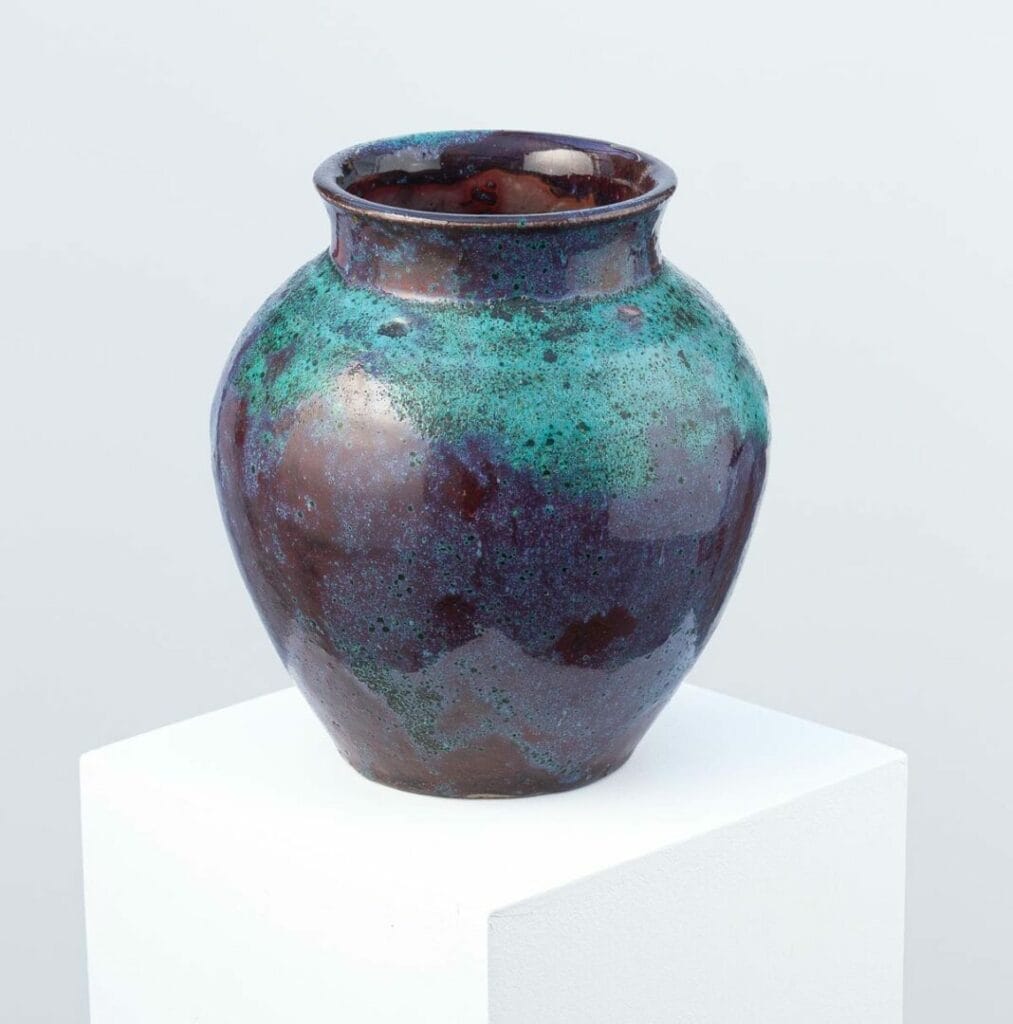 Conçu par Eugène Lion, de l'école de Carriès, ce vase en grès avec émail rouge et vert-de-gris illustre le Japonisme et le Wabi-Sabi, fabriqué à Saint-Amand-en-Puisaye.
