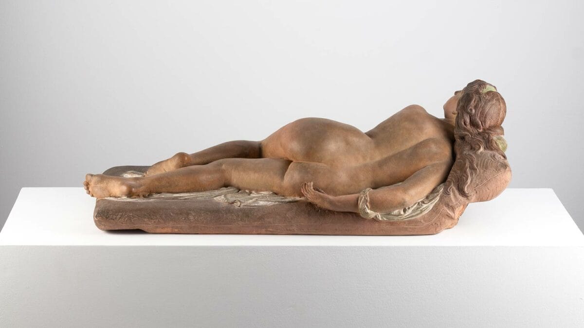 Pièce en terre cuite polychromée figurant une femme nue allongée sur un divan. Cette création, nommée "La Vanité", a été réalisée par Joseph Félon pour le Salon de 1866.