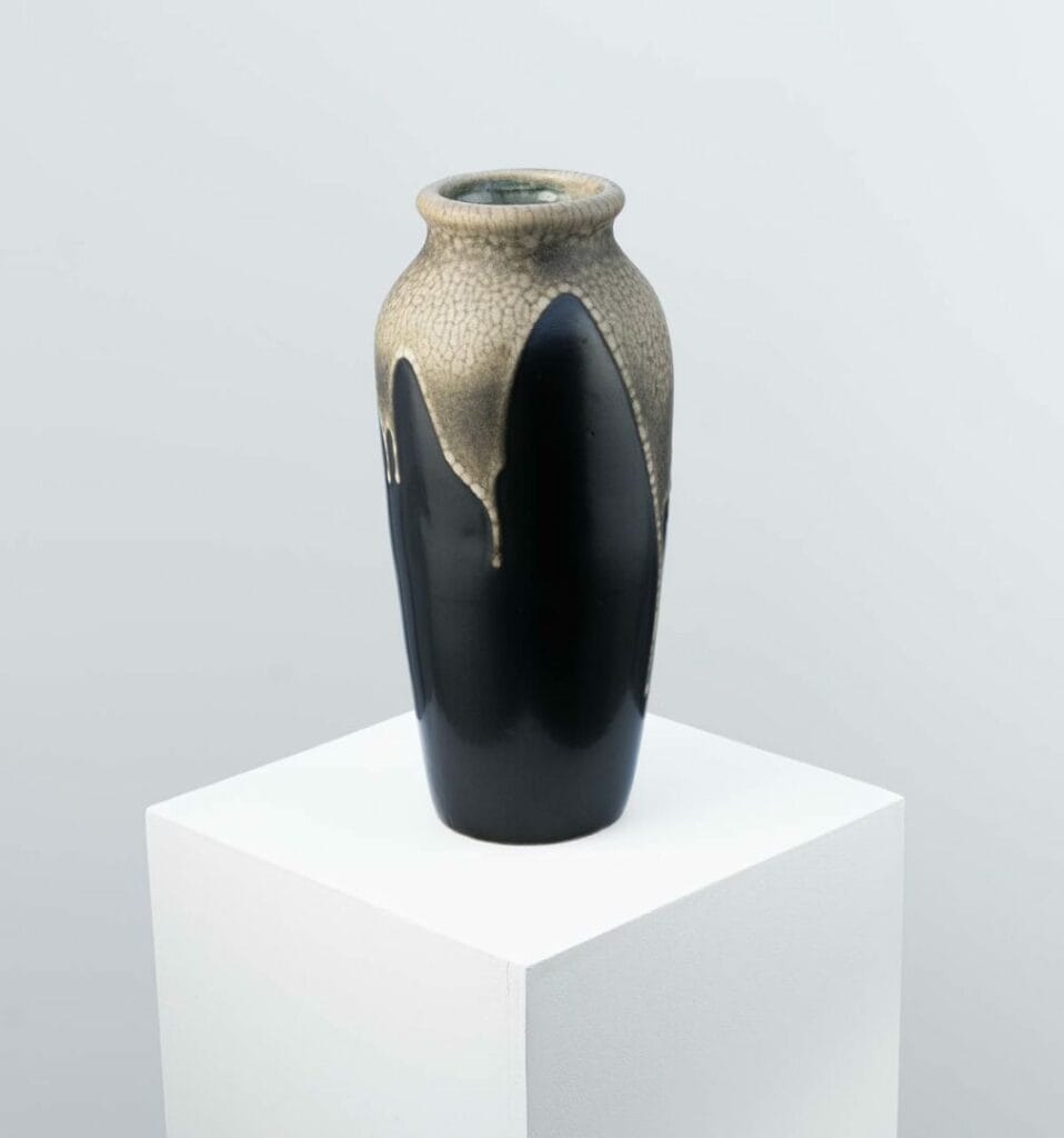 An ovoid stoneware vase created by Léon Pointu, an eminent ceramist from the Carriès school, made in Saint-Amand-en-Puisaye. The black enamelled base is topped by a beige glaze with a snakeskin motif running from the neck to the top of the vase. The base is numbered and signed Pointu.