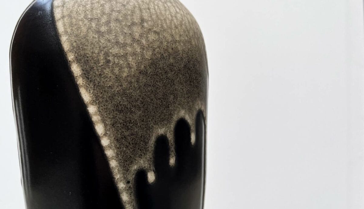 Vase ovoïde en grès signé Léon Pointu, figure notable de l'école de Carriès, confectionné à Saint-Amand-en-Puisaye. La base noire émaillée est surmontée d'une couverte beige peau-de-serpent recouvrant le col. La base, numérotée, est signée Pointu.