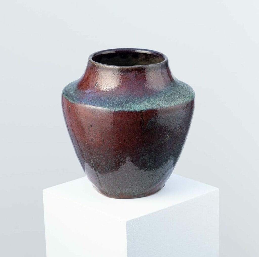 Crafted by Eugène Lion, a Carriès school ceramist, this red-glazed stoneware vase shows influences of Japonism and Wabi-Sabi, originating from Puisaye.