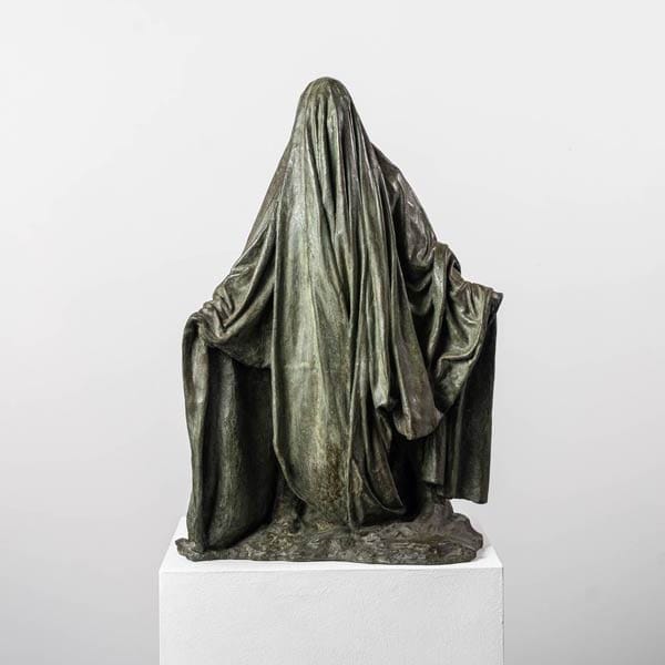 "Veiled Shadow II," a bronze sculpture by Guy Le Perse, is inspired by Dante's Divine Comedy. It illustrates the hypocrites confined to the sixth trench of the eighth circle of Hell, designated for fraudsters.
